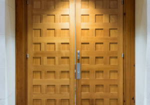 Two large, wooden city council chamber doors are closed.