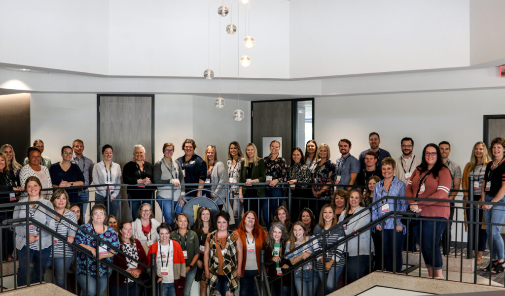 50 clerks pose on the stairs of the League of Minnesota Cities building in St. Paul