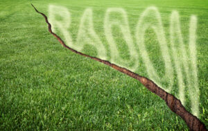 A green mowed lawn with a diagonal crack with radon gas escaping.