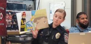 Two police officers read books to students through Plymouth's Books and Badges program.