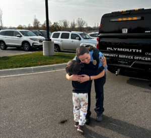 A police officer hugs a student participant from the Books and Badges Program.