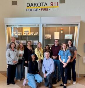 League employees pose for a photo in the lobby of the Dakota 911 communications center