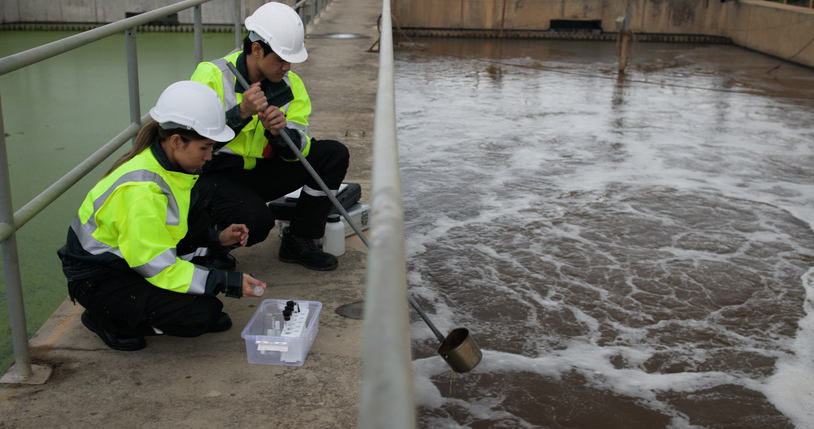 Safety and environmental engineers are checking the water quality at a wastewater treatment plant in the industrial estate.