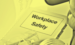 High contrast black and yellow image featuring a closed binder that reads "Workplace Safety"