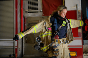 Rochester Firefighter Mandee Marx is shown putting on her firefighting gear.