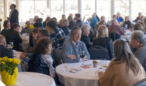 People gathered around tables in a ballroom