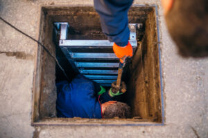 Workers enter underground well to make repairs
