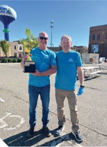 Two men in standing in a parking lot.