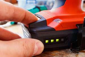 Someone checks the battery level of a lithium-ion-powered tool.