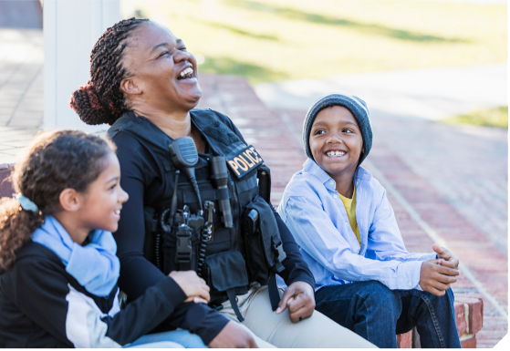 Police person with two young children. All look happy.