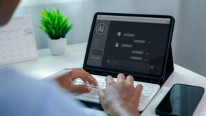 Person typing on keyboard while using artificial intelligence AI chatbot prompt interface on digital tablet screen for automated communication, data analysis, and productivity.